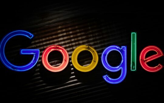 Google logo neon sign as the company announces a restructuring of its divisions and leadership to accelerate its AI initiatives.